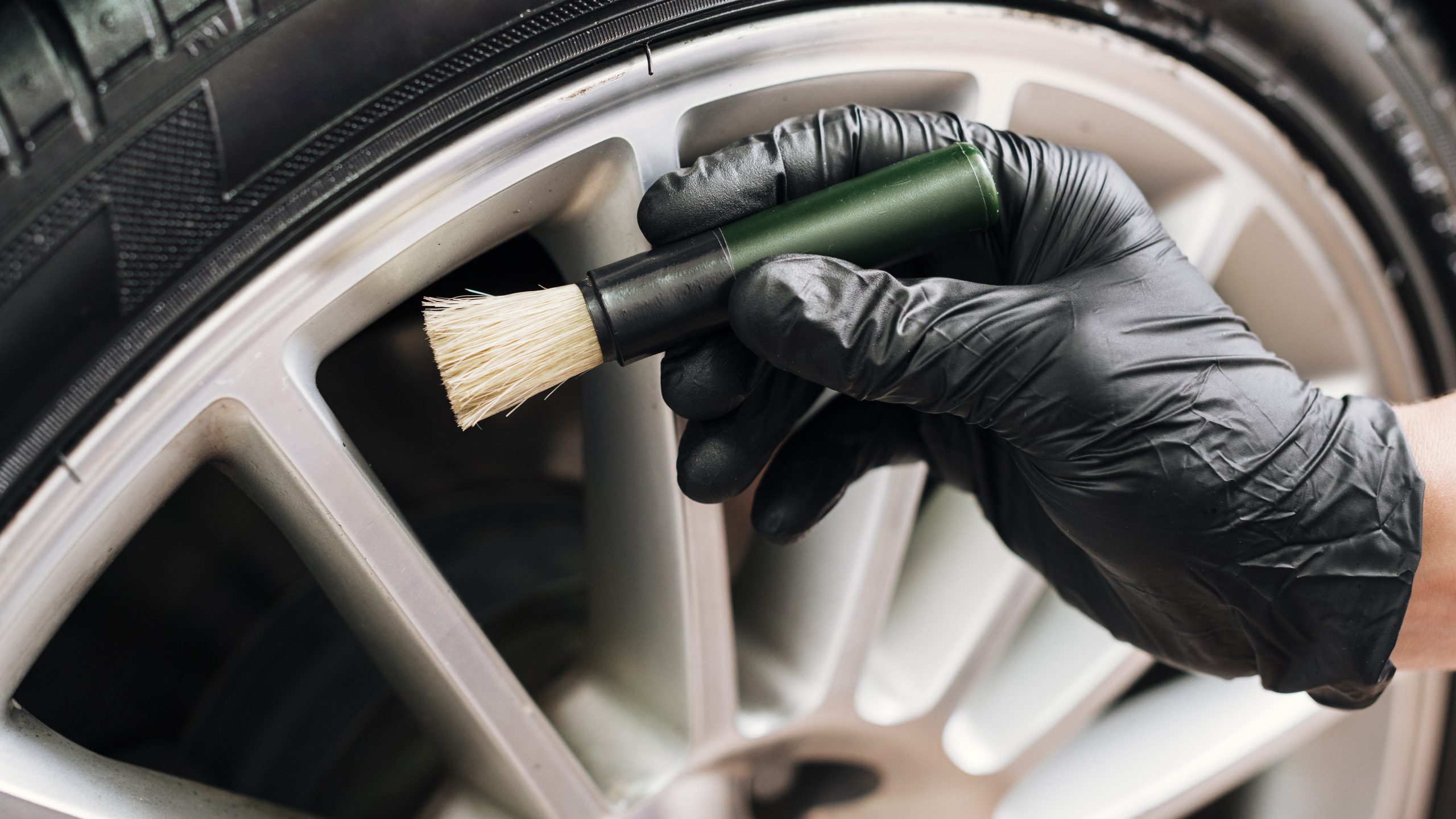 Man cleaning rim of car